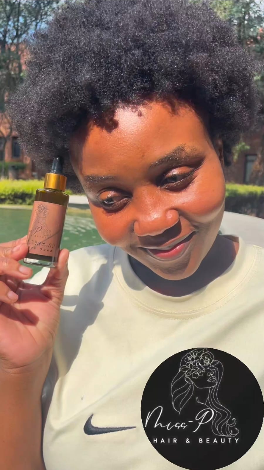 Model with healthy hair holding MISSP Hair Growth Oil